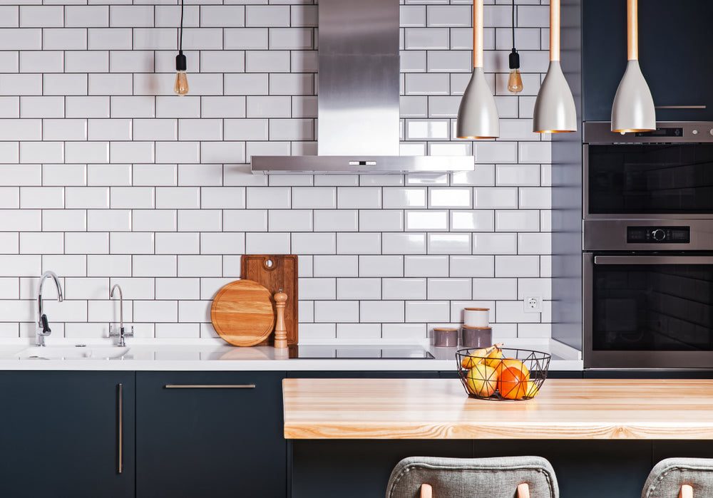 Kitchen with white metro tiles and dark navy cabinets